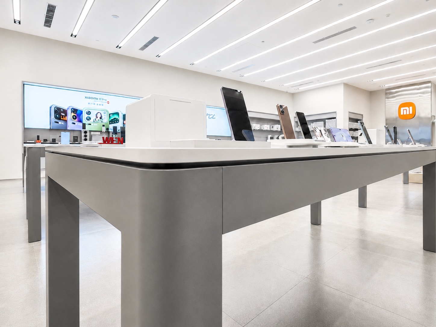 Xiaomi Mobile Store low-angle product table detail showing refined fixture edges, smartphone stands, accessories, and minimal retail finishing