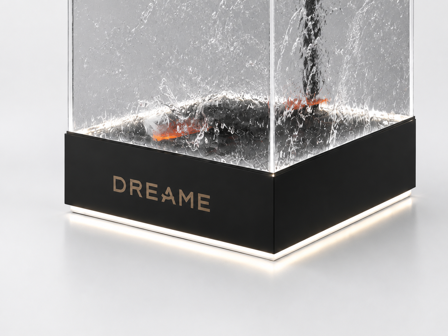 Close detail of DREAME water flow demonstration display base showing illuminated plinth edge, black fascia and acrylic corner