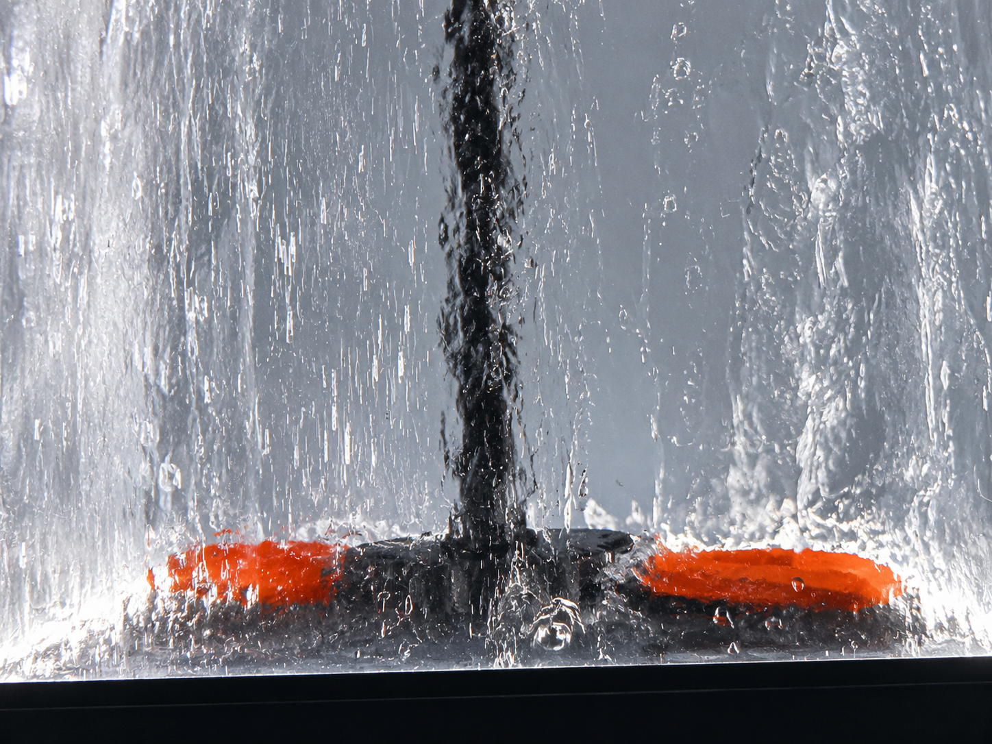 Close detail of internal DREAME water flow demonstration mechanism showing turbulent water curtain and brush elements