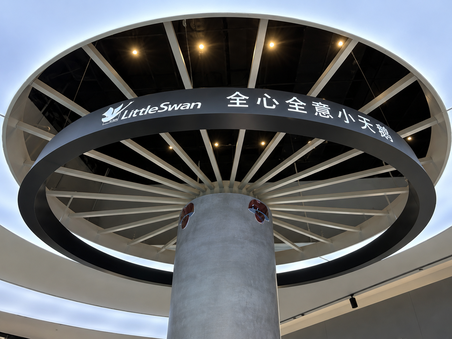 Close upward view of Little Swan illuminated brand ring, Chinese slogan and radial canopy structure