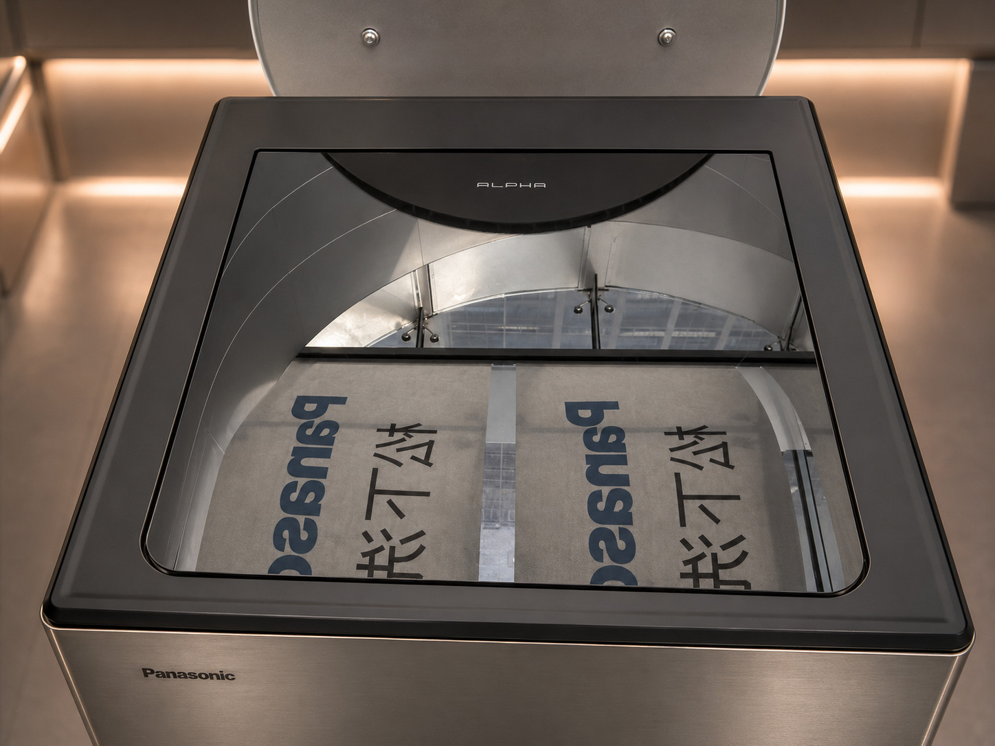Close-up of Panasonic ALPHA top viewing window showing the demonstration material inside the laundry robot display
