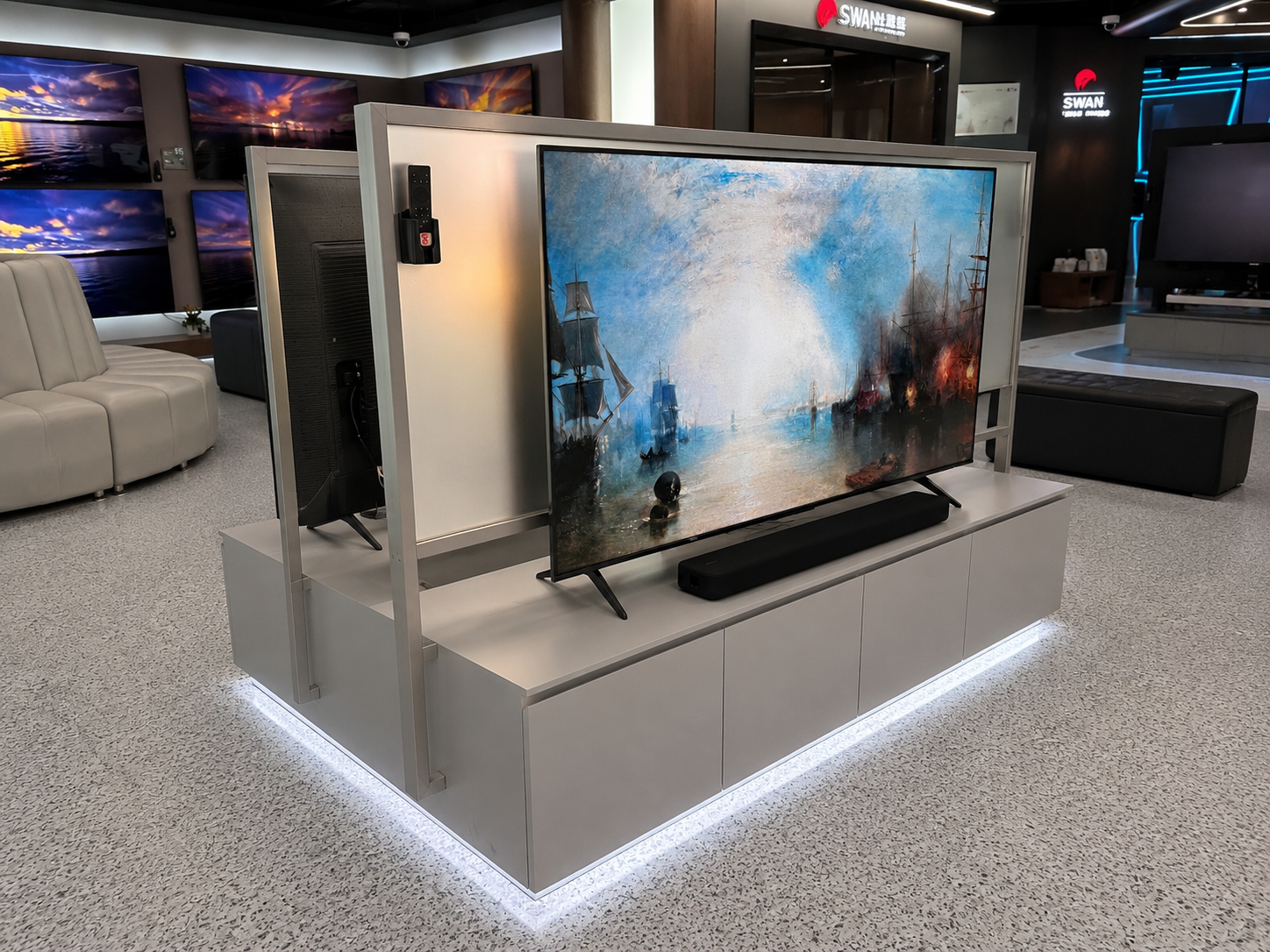Three-quarter view of TCL television display system showing one screen face, central frame, soundbar, storage cabinet and perimeter lighting